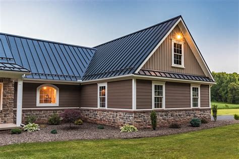 grey brick house with metal roof|matching brick and roof colors.